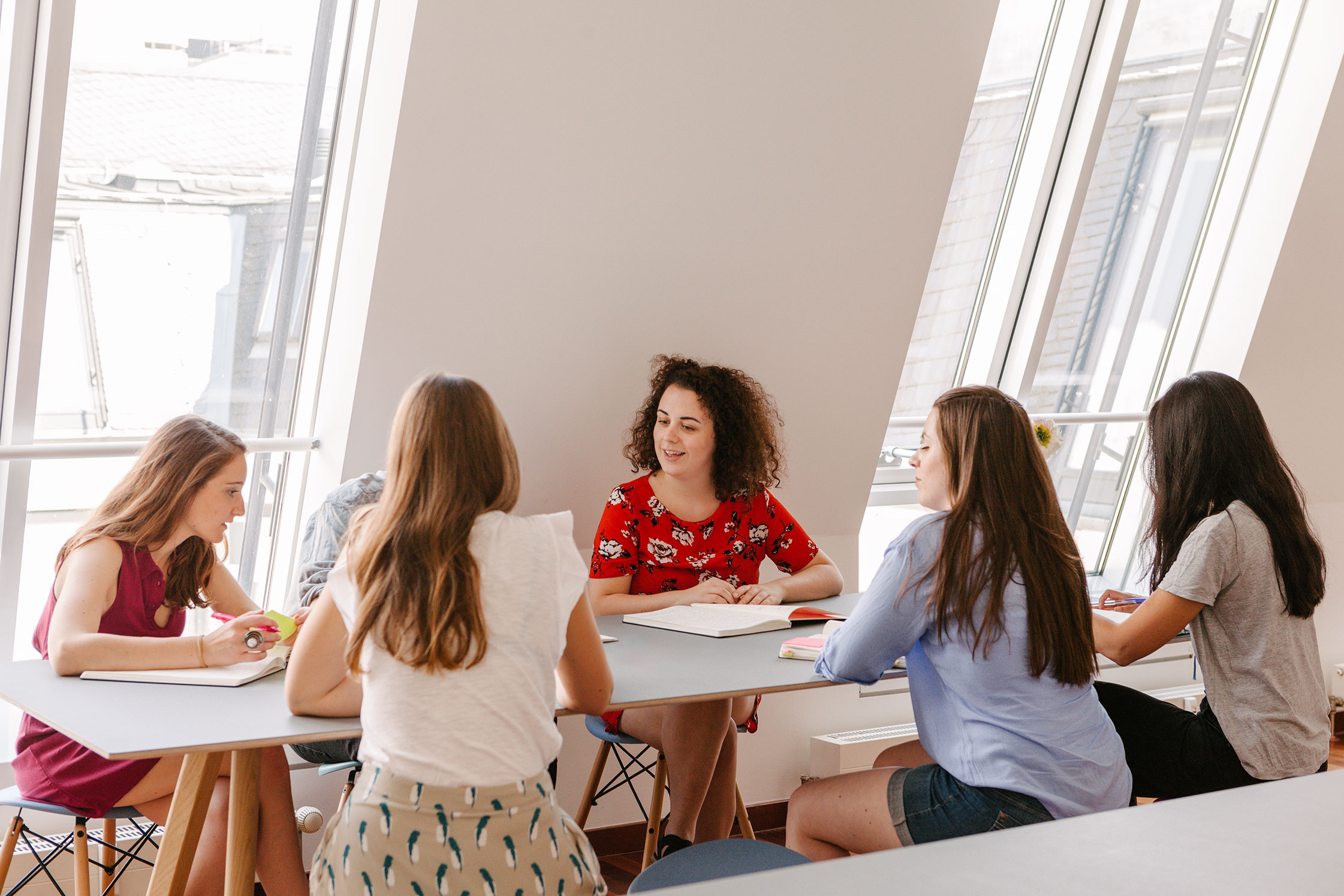 Six ctrl QS team members sitting around a table having a conversation